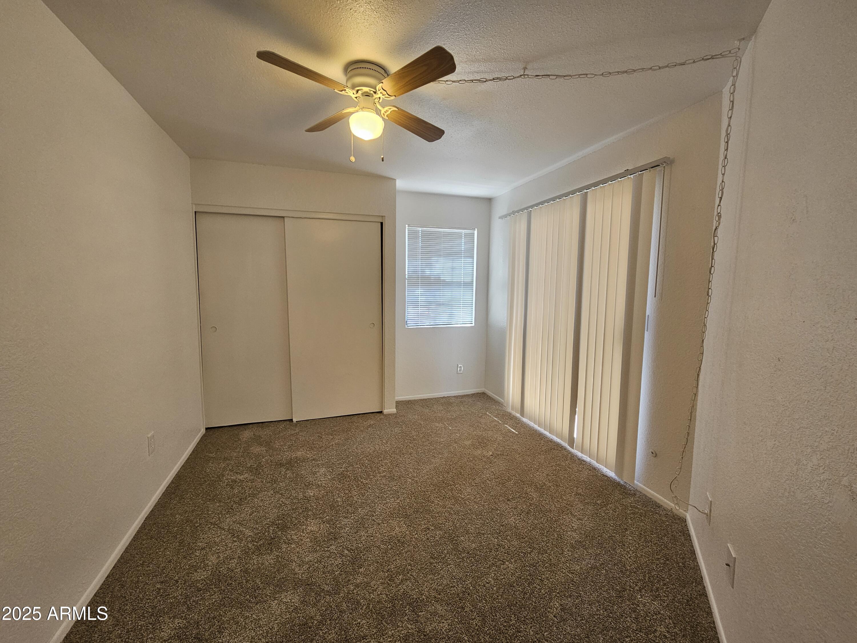 1370 South Price Road, Unit 115 Tempe, AZ 85281 - Photo 11 of 14 an empty room with a chandelier fan and closet