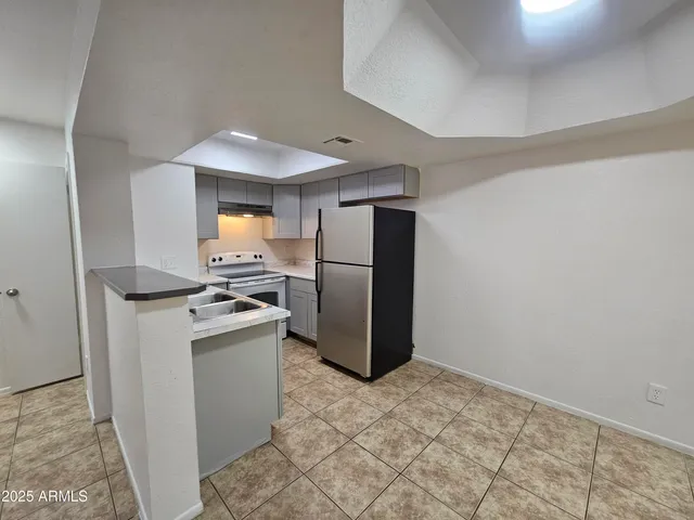 a kitchen with stainless steel appliances granite countertop a refrigerator a stove and a sink