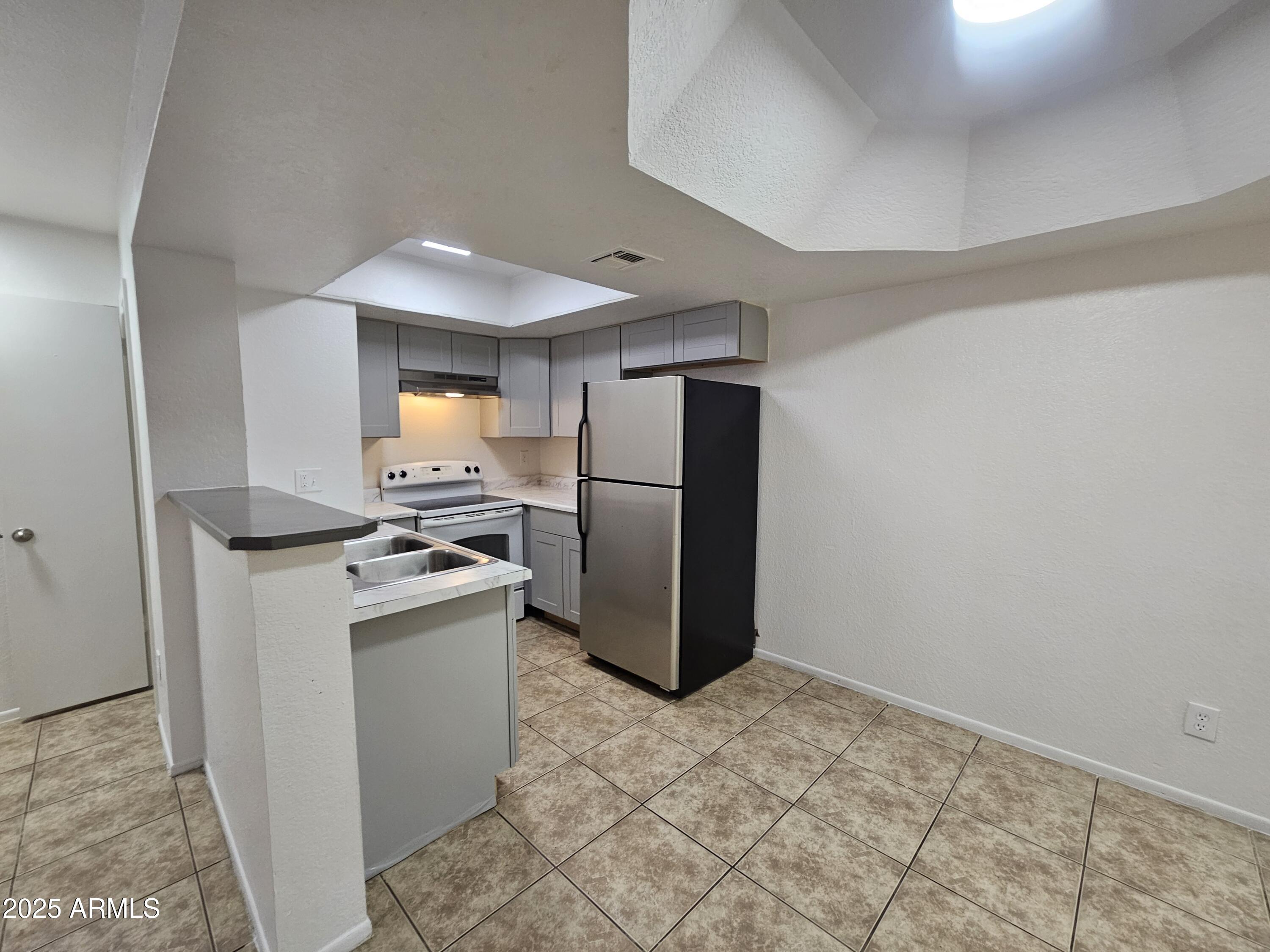 1370 South Price Road, Unit 115 Tempe, AZ 85281 - Photo 4 of 14 a kitchen with stainless steel appliances granite countertop a refrigerator a stove and a sink
