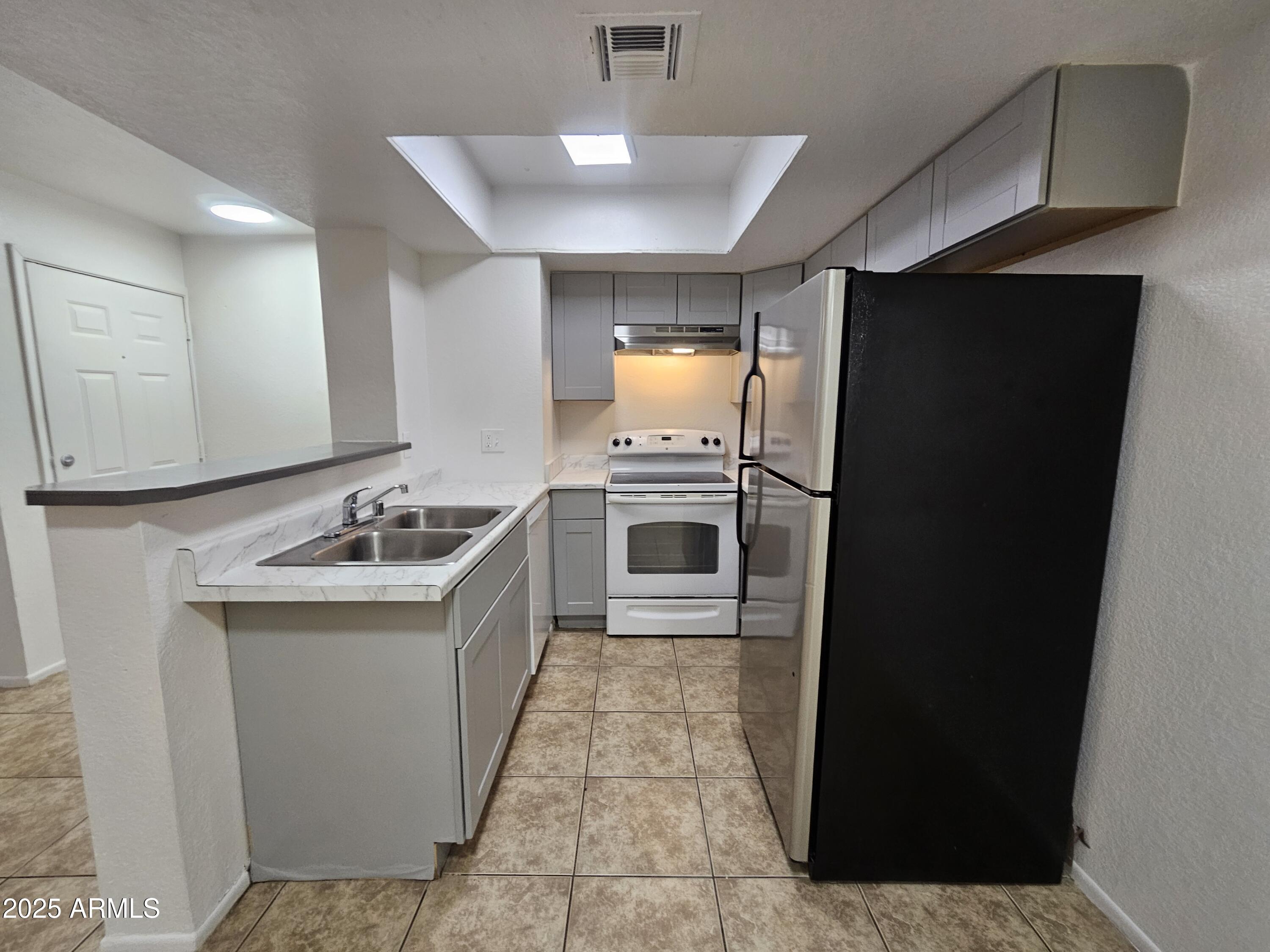 1370 South Price Road, Unit 115 Tempe, AZ 85281 - Photo 5 of 14 a kitchen with a sink stove and refrigerator