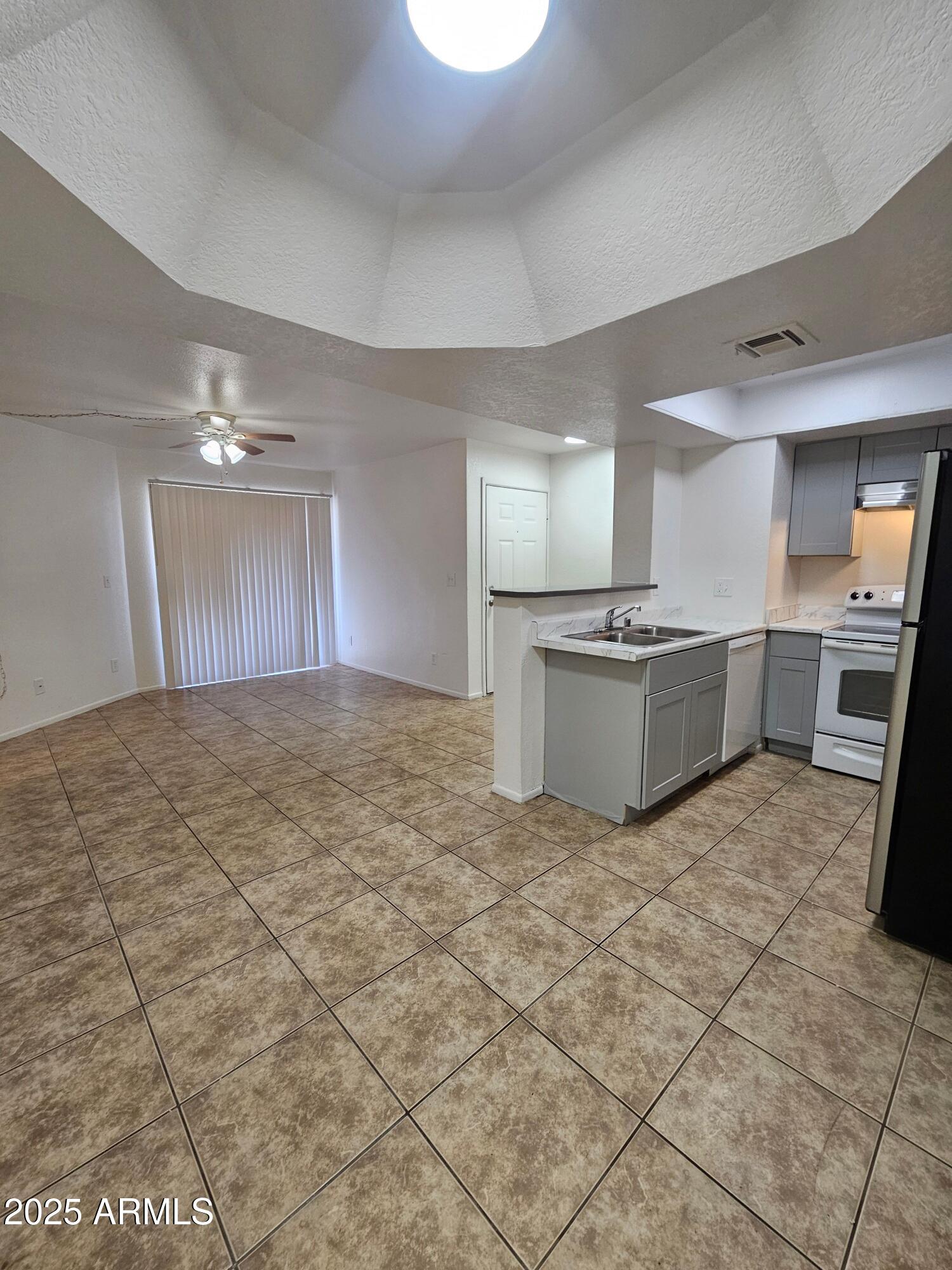 1370 South Price Road, Unit 115 Tempe, AZ 85281 - Photo 7 of 14 a large kitchen with cabinets and stainless steel appliances
