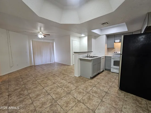 a view of a kitchen with a sink a refrigerator and cabinets