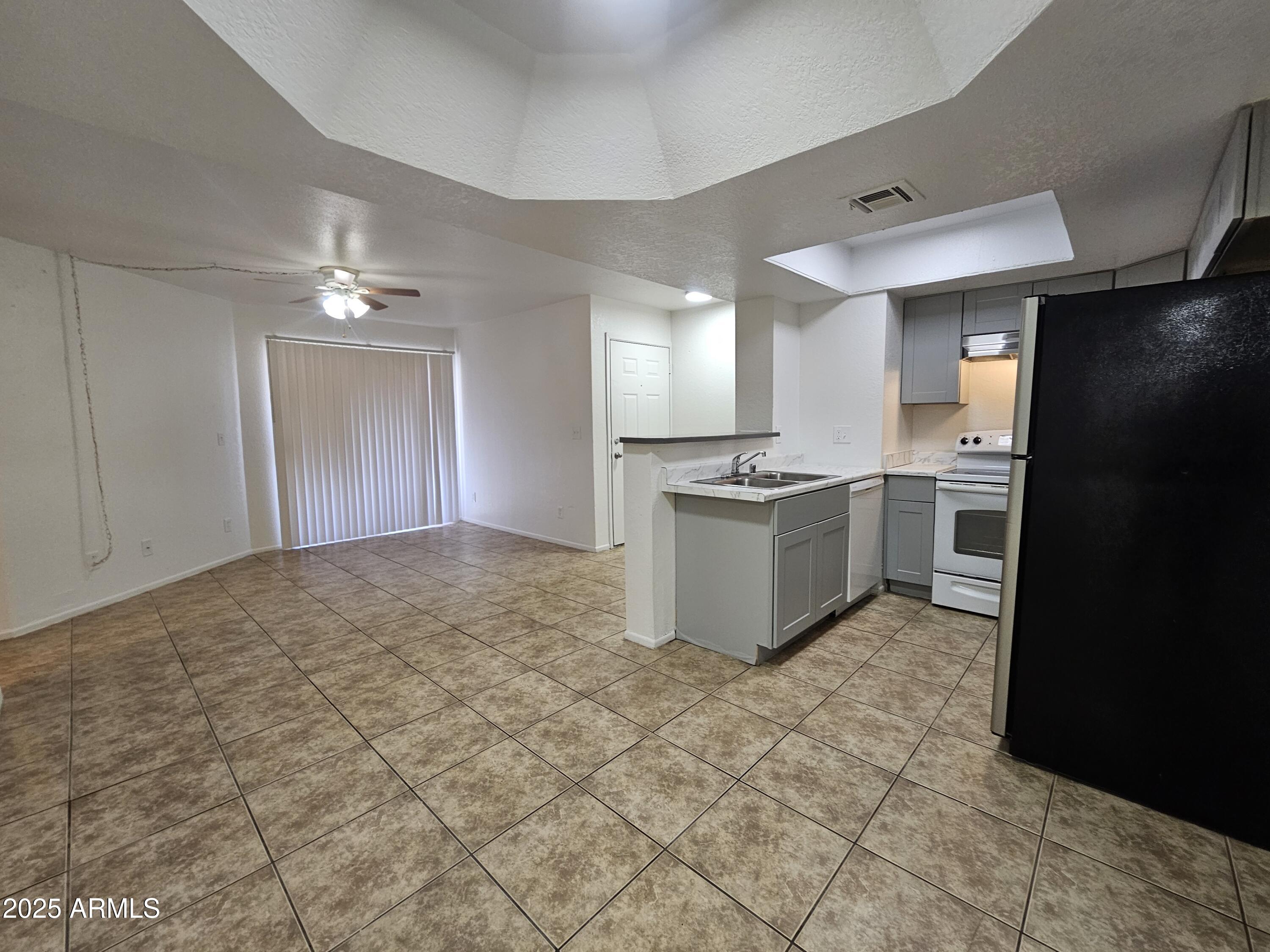 1370 South Price Road, Unit 115 Tempe, AZ 85281 - Photo 8 of 14 a view of a kitchen with a sink a refrigerator and cabinets