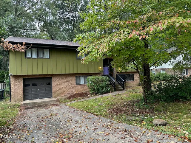 a front view of a house with a garden and yard
