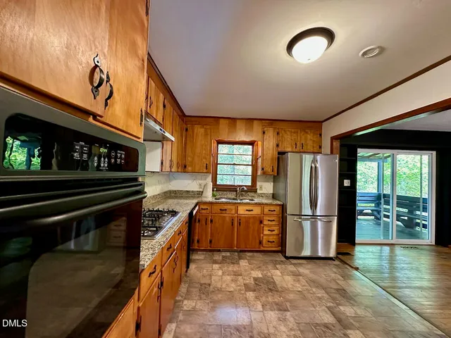 an empty room with wooden floor mirror and windows