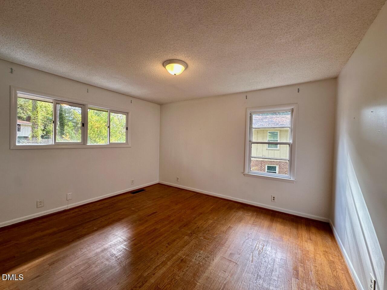 3421 Huntleigh Drive Raleigh, NC 27604 - Photo 16 of 27 a view of an empty room with wooden floor and a window
