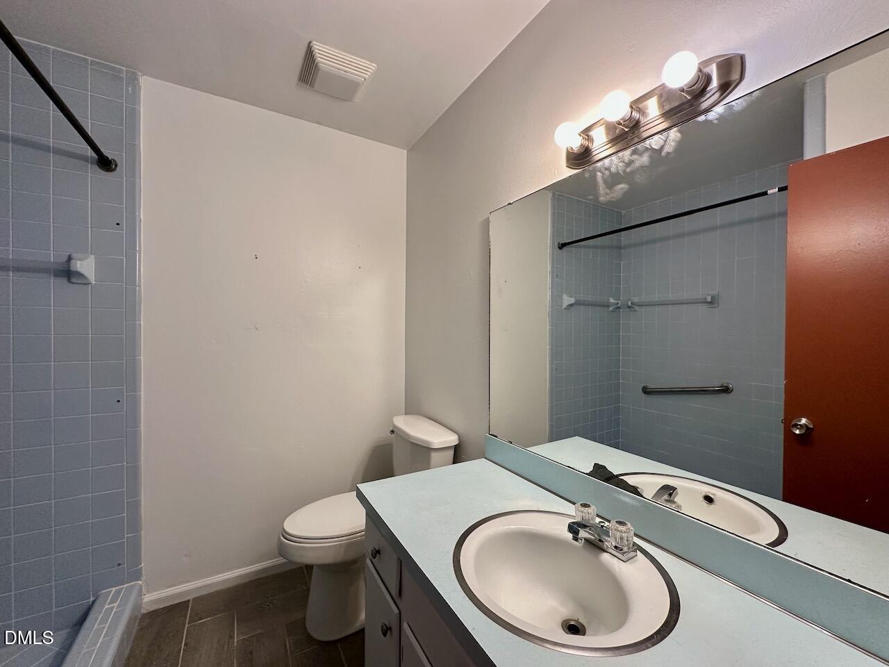 3421 Huntleigh Drive Raleigh, NC 27604 - Photo 17 of 27 a bathroom with a toilet a sink a mirror and vanity