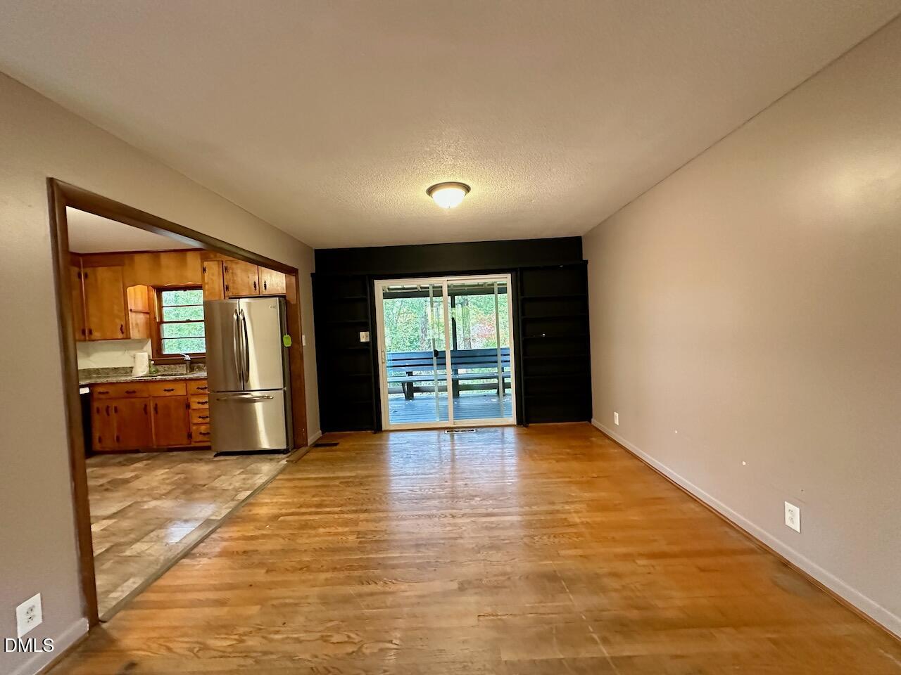 3421 Huntleigh Drive Raleigh, NC 27604 - Photo 8 of 27 a view of an empty room with a window and wooden floor