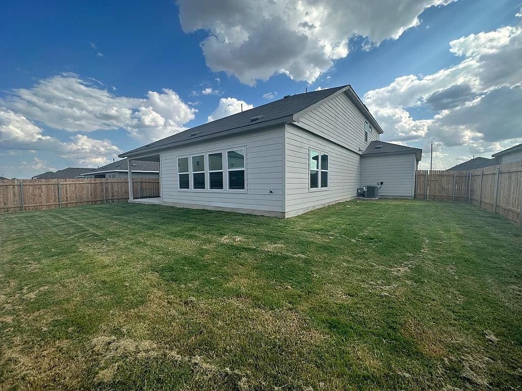 160 River Rise Road Kyle, TX 78640 - Photo 34 of 35 Expansive backyard featuring a manicured lawn, a covered patio, and privacy fencing