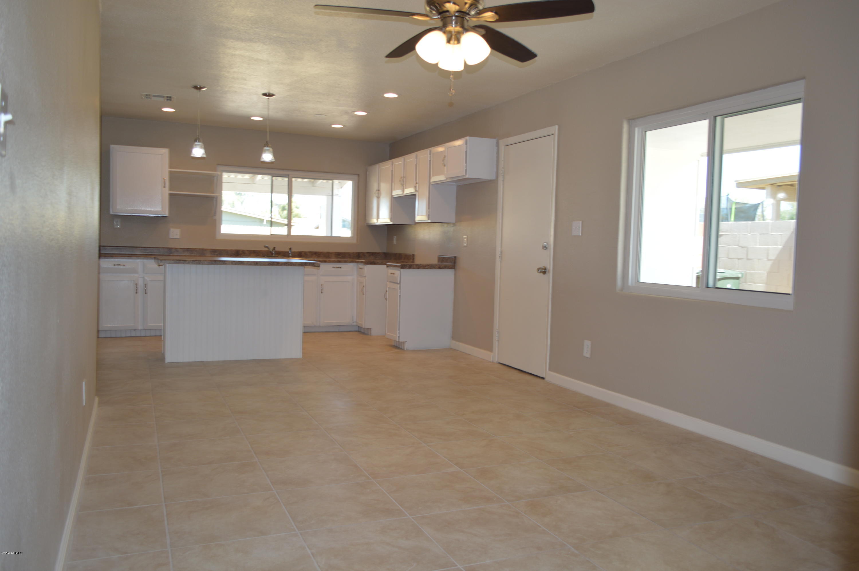 1602 West Darrel Road Phoenix, AZ 85041 - Photo 12 of 39 a large kitchen with stainless steel appliances granite countertop a sink and dishwasher a stove a refrigerator with white cabinets