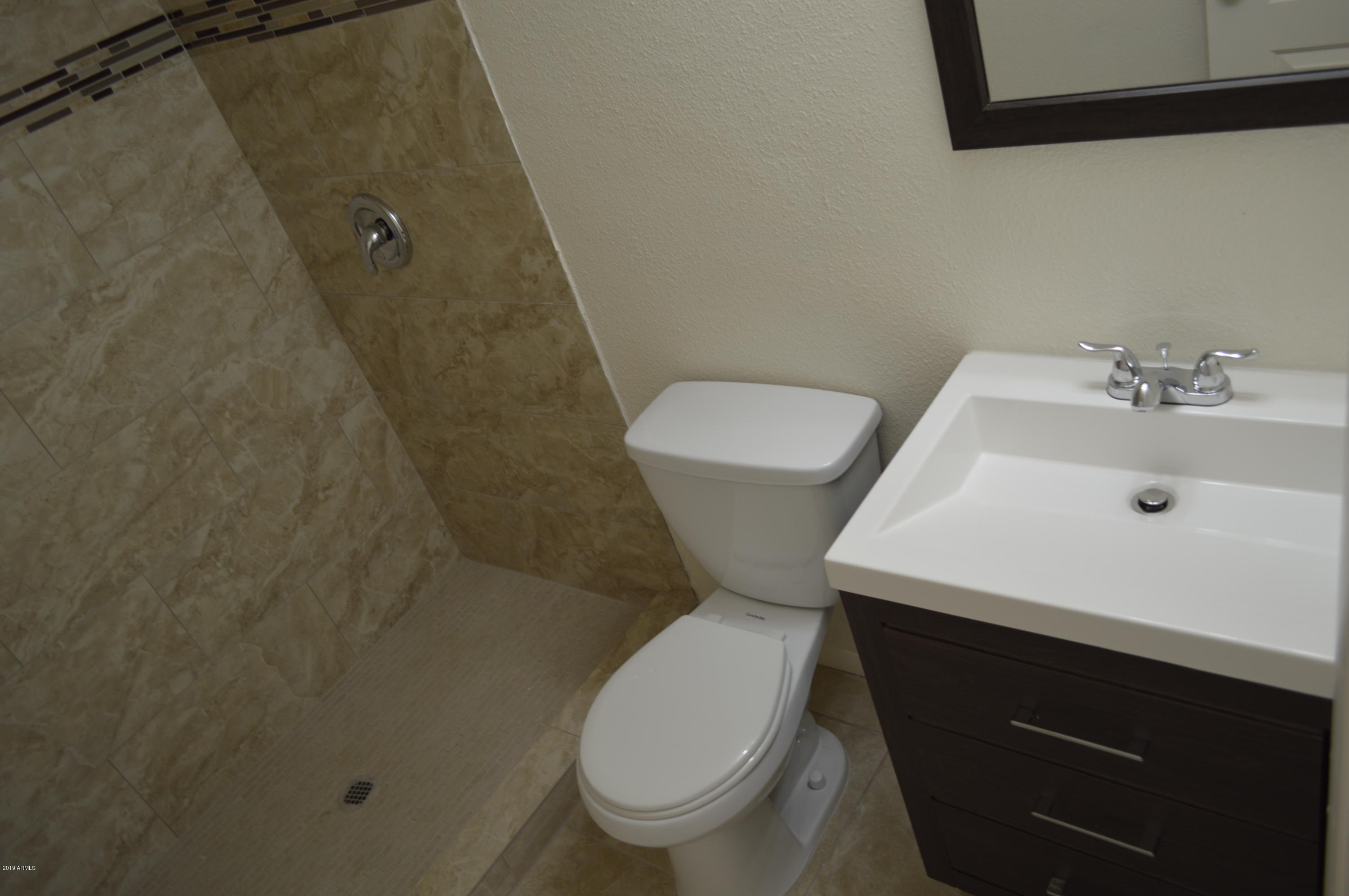 1602 West Darrel Road Phoenix, AZ 85041 - Photo 30 of 39 a white toilet sitting next to a bathroom sink