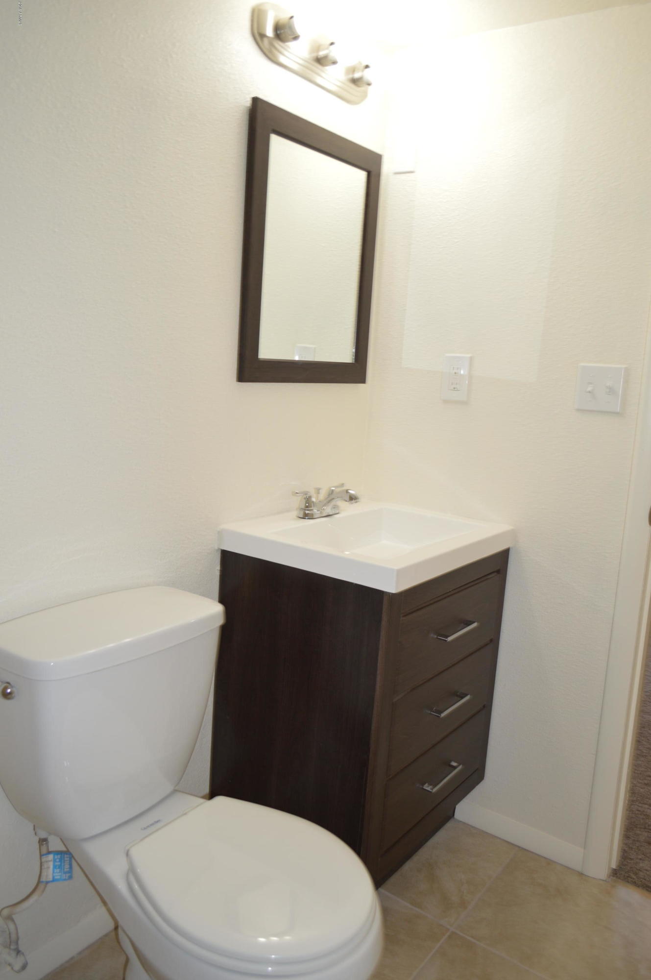 1602 West Darrel Road Phoenix, AZ 85041 - Photo 32 of 39 a bathroom with a toilet mirror vanity and a sink