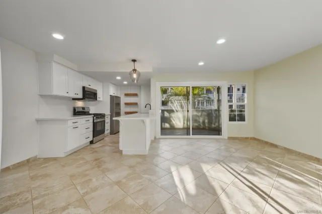 a view of a kitchen with refrigerator and windows