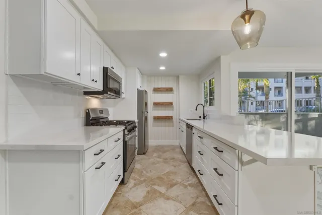 a kitchen with stainless steel appliances granite countertop a stove refrigerator and cabinets