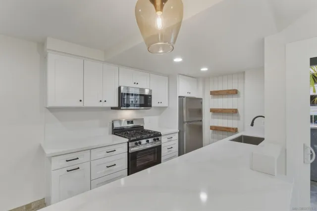 a kitchen with stainless steel appliances a refrigerator sink and stove
