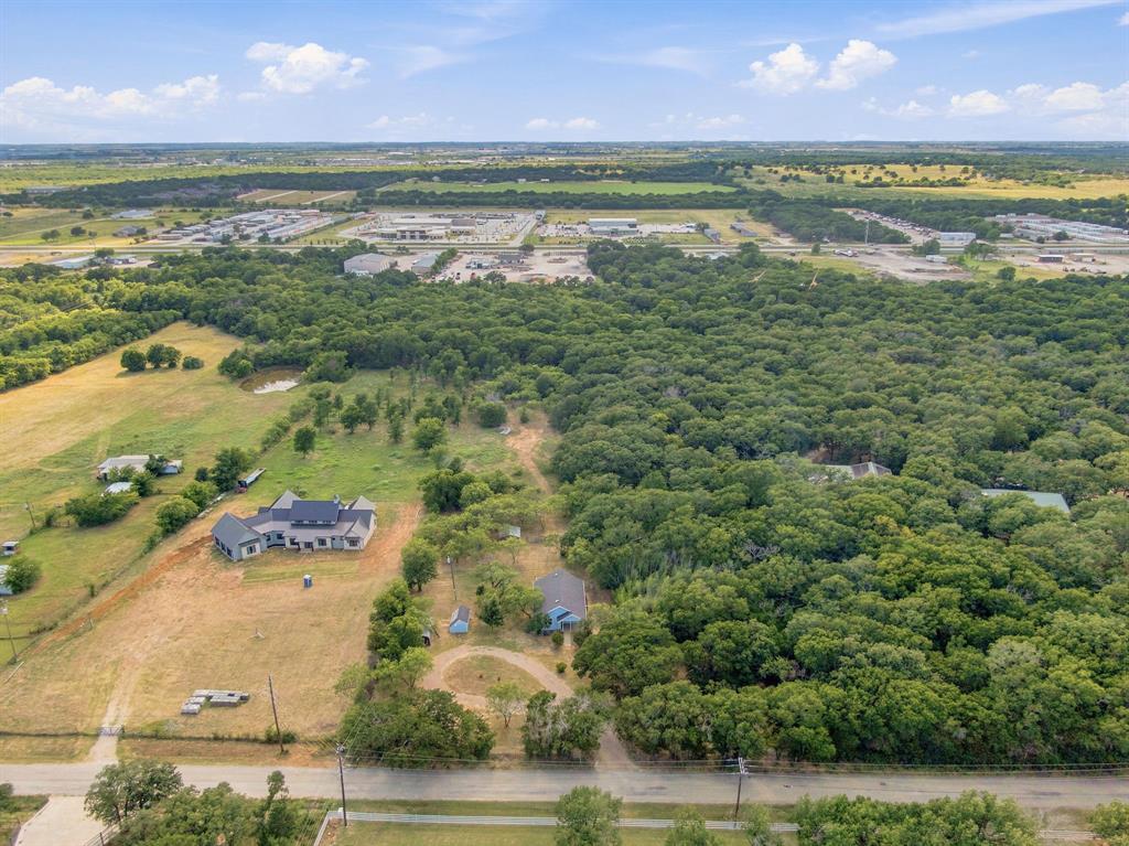 3325 Dove Creek Road Cleburne, TX 76031 - Photo 31 of 40 Expansive property featuring a large residence, a secondary structure, and a pond