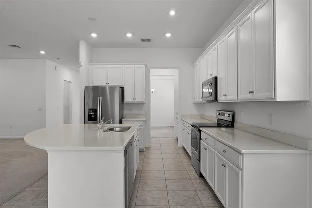 a kitchen with stainless steel appliances a sink stove and refrigerator