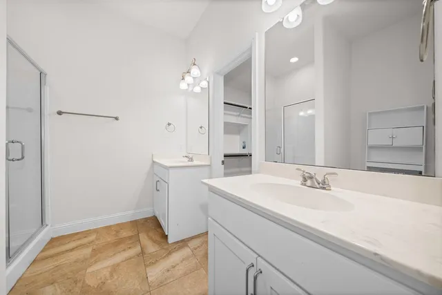 a spacious bathroom with a sink double vanity and a mirror