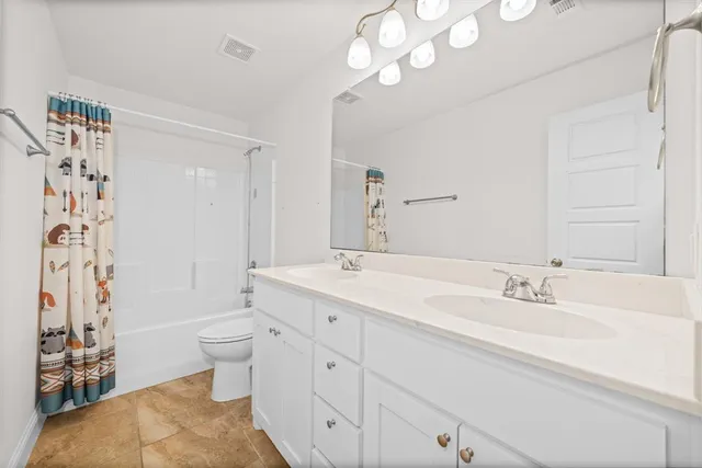 a bathroom with a granite countertop sink a toilet and shower
