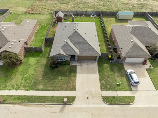an aerial view of a house with swimming pool and a yard