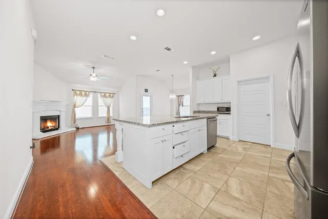 a kitchen with stainless steel appliances kitchen island hardwood floor sink and stove