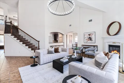 a living room with fireplace furniture and a large window