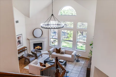 a living room with furniture a fireplace and a large window