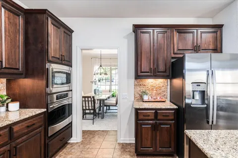 a kitchen with granite countertop a refrigerator stove and oven