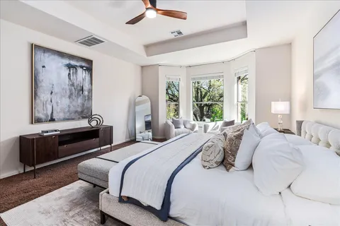 a bedroom with bed and a large window