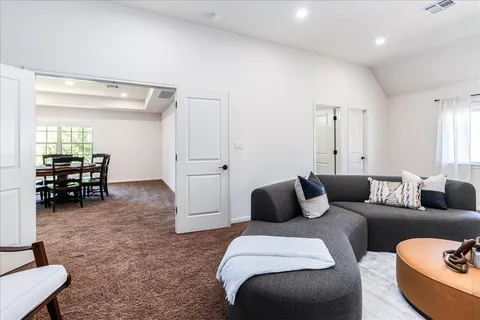 a living room with furniture and a view of bedroom