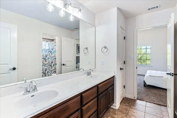 a en suite bathroom with a double vanity sink a mirror and a shower