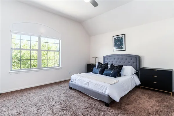 a bedroom with a bed lamp and a window