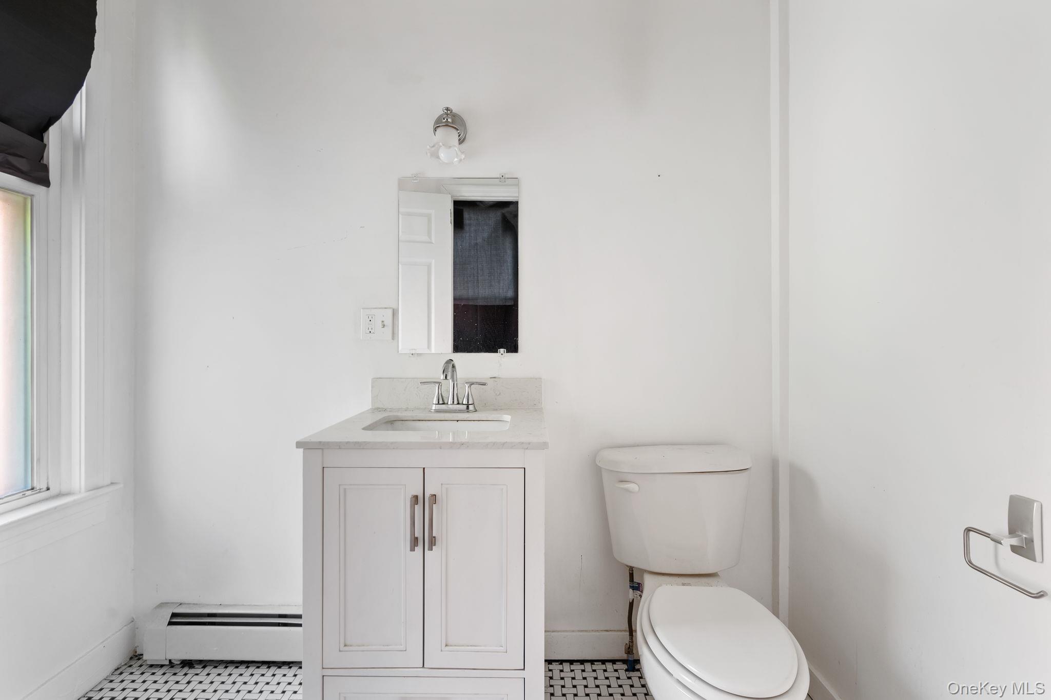 77 Academy Street Poughkeepsie, NY 12601 - Photo 13 of 30 Half bathroom featuring baseboard heating and vanity