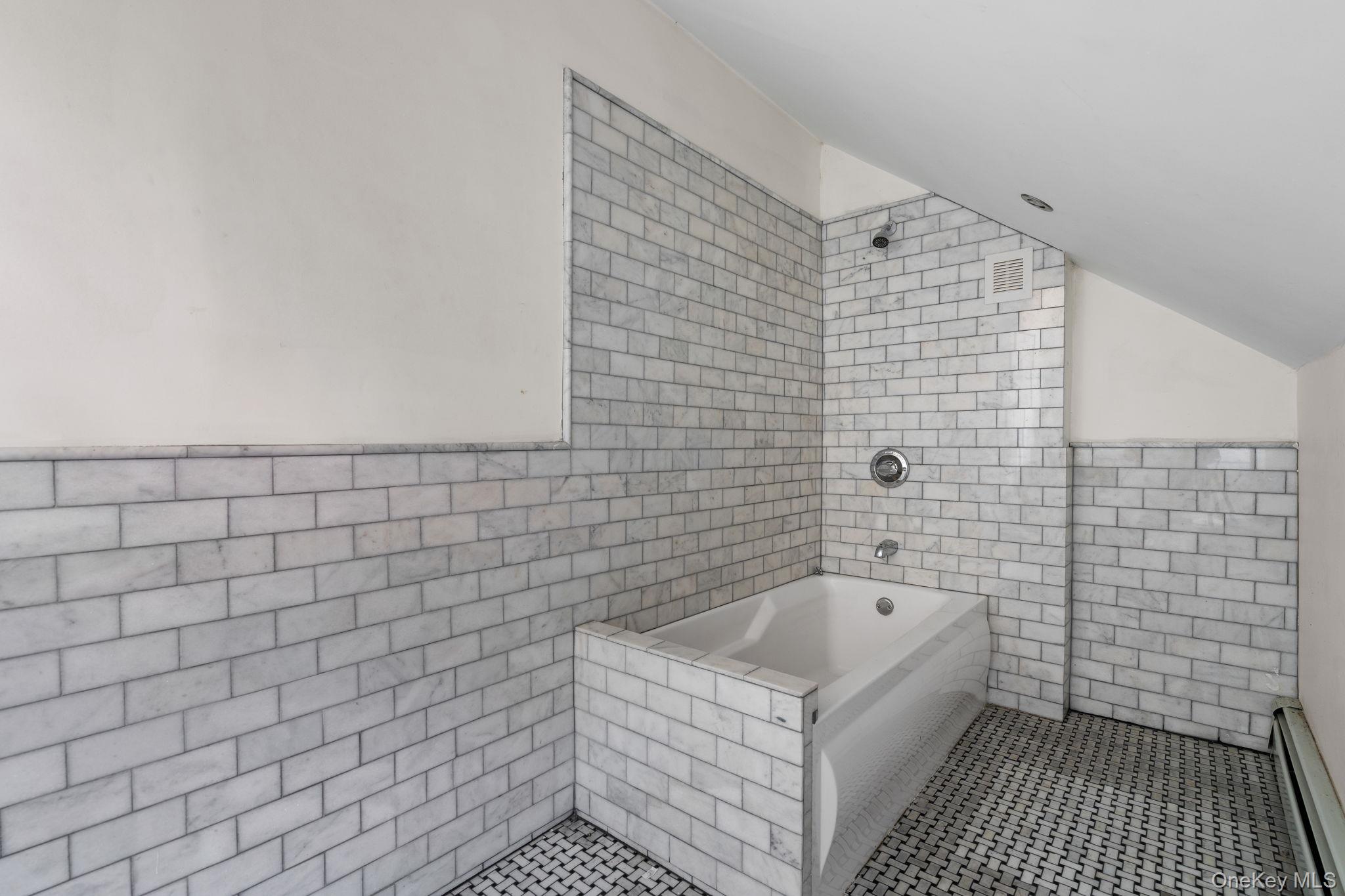 77 Academy Street Poughkeepsie, NY 12601 - Photo 19 of 30 Bathroom with tile walls, a baseboard heating unit, lofted ceiling, and tile patterned flooring