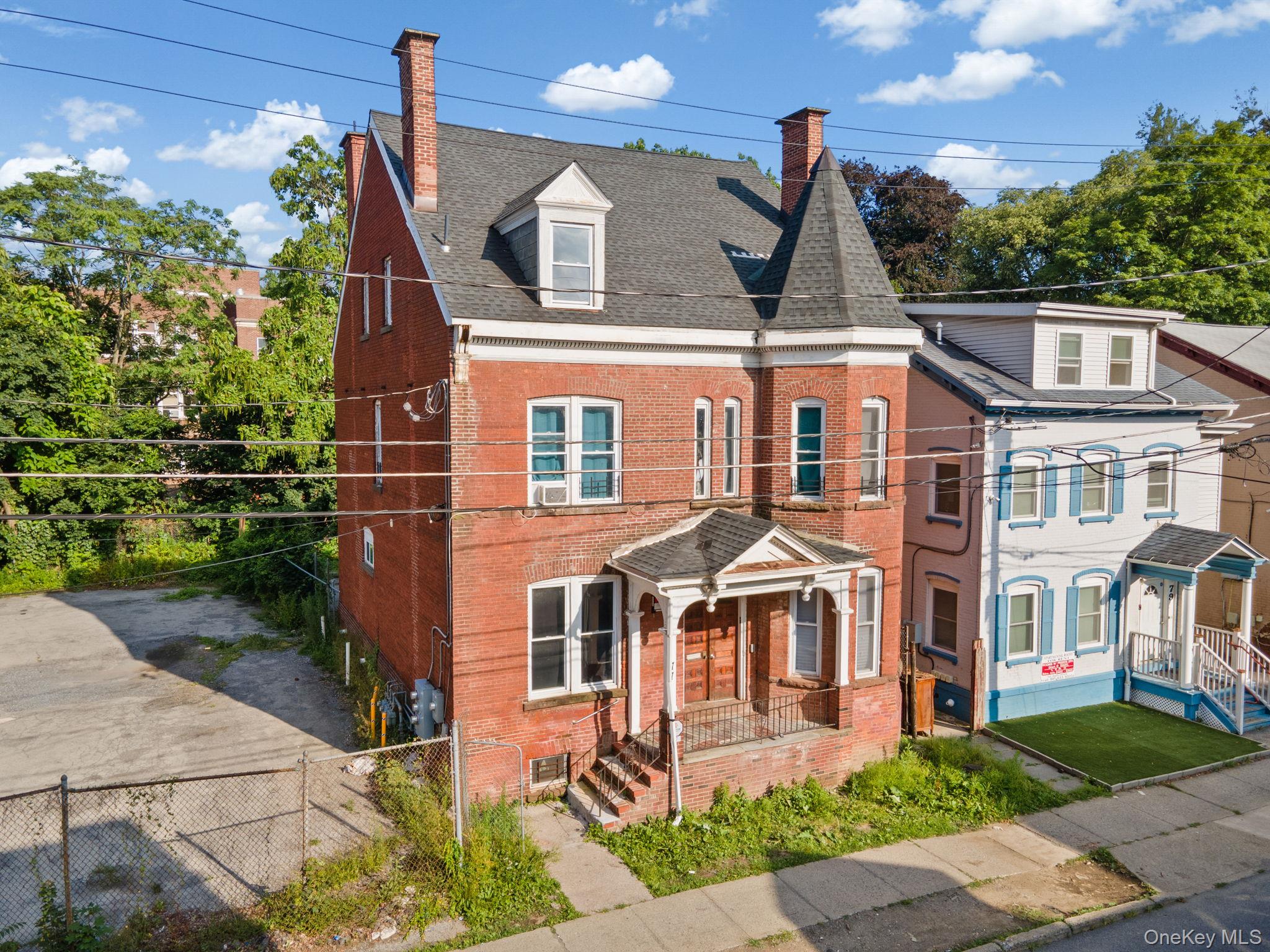 77 Academy Street Poughkeepsie, NY 12601 - Photo 3 of 30 View of front of home featuring a chimney, roof with shingles, brick siding, and a fenced front yard
