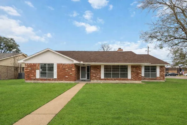 a front view of a house with a yard and trees