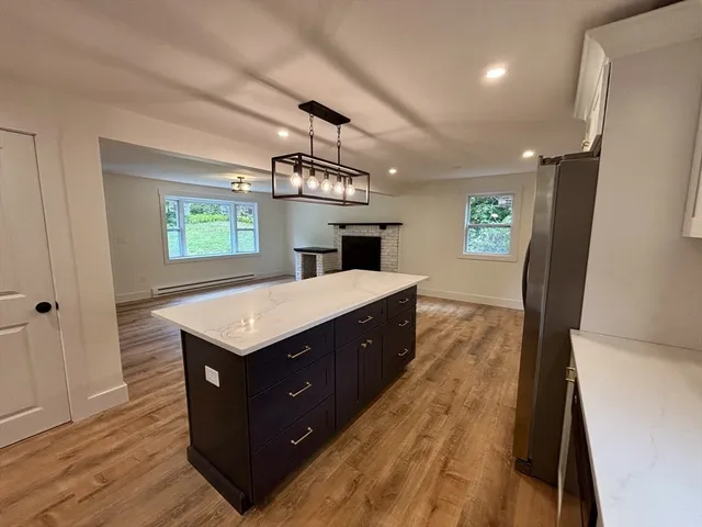 a kitchen with a counter space wooden floor and windows