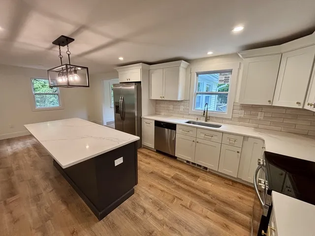 a kitchen with a sink a window and cabinets