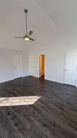 a view of empty room with wooden floor and ceiling fan