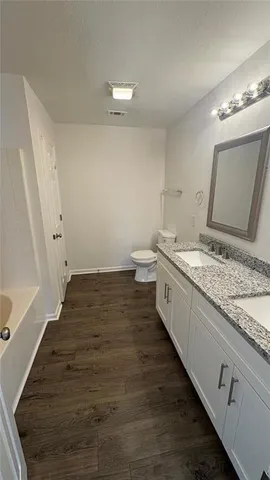 a spacious bathroom with a granite countertop sink and a mirror