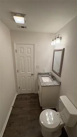 a bathroom with a toilet a sink and mirror