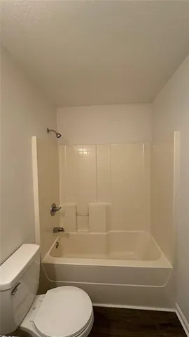 a bathroom with a toilet and a bath tub