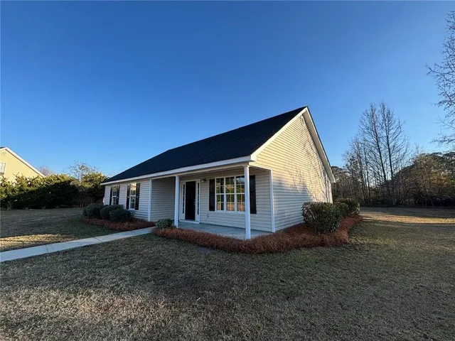a view of a house with backyard and trees