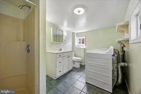 a bathroom with a double vanity sink toilet and shower