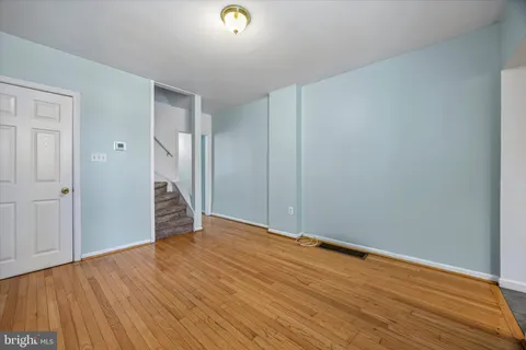 a view of an empty room with wooden floor