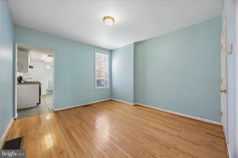 an empty room with wooden floor and a bathroom