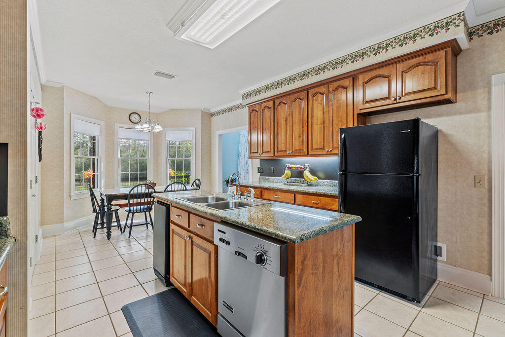 728 Otter Pond Road Westville, FL 32464 - Photo 12 of 39 a kitchen with stainless steel appliances granite countertop a refrigerator a stove and a sink with granite countertops