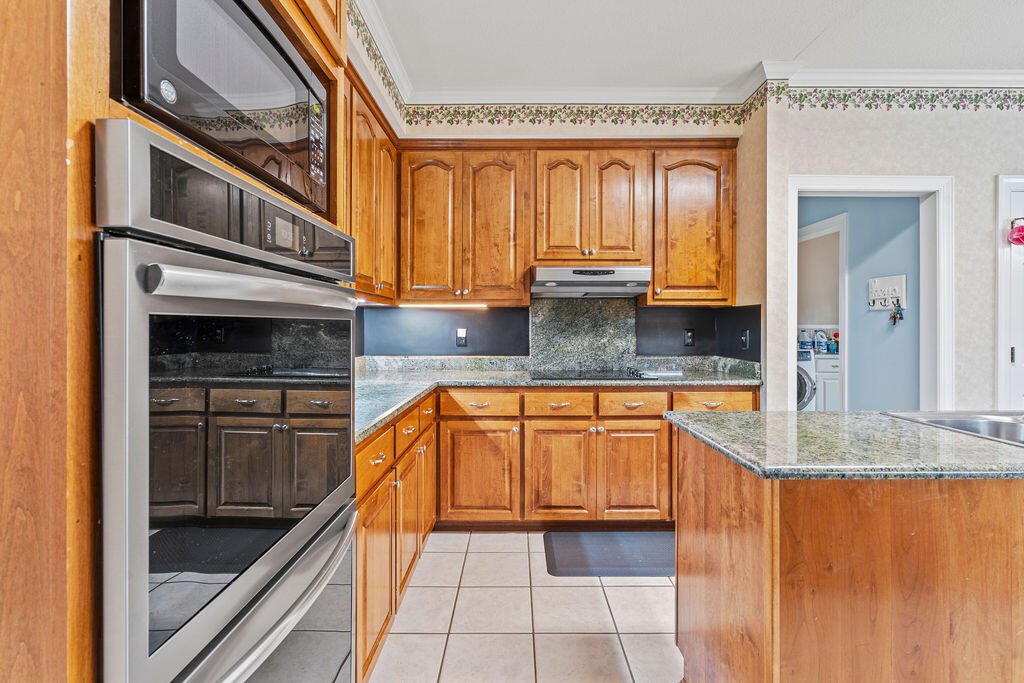 728 Otter Pond Road Westville, FL 32464 - Photo 13 of 39 a kitchen with stainless steel appliances granite countertop a stove a sink and a microwave
