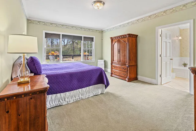 a spacious bedroom with a bed and glass door