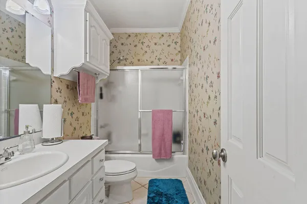 a bathroom with a sink toilet vanity and shower